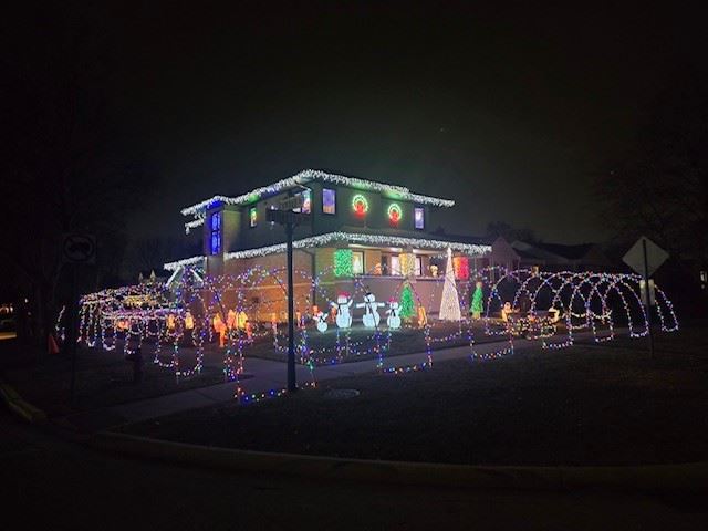 2 story house with lighted arches, snowmen, Christmas trees and wreaths